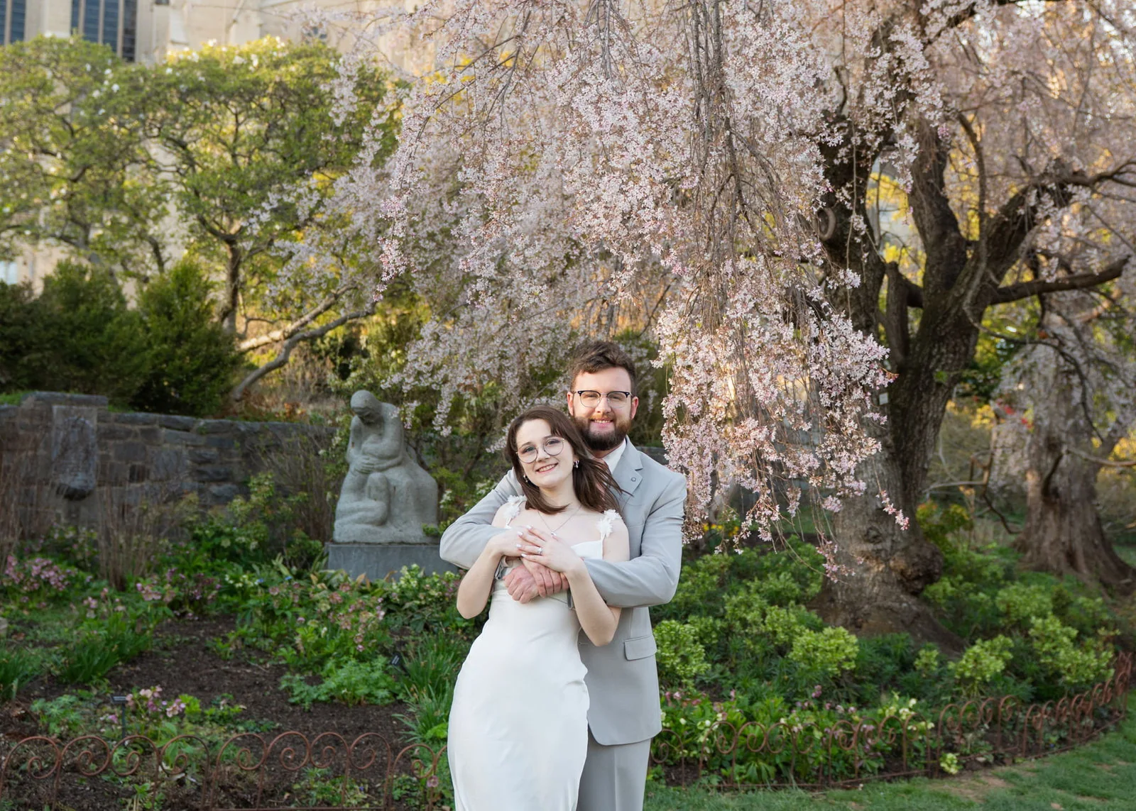 Jeremy and Winter embracing beneath flowering trees